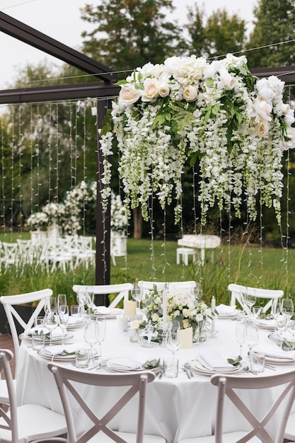 Mesa de casamento servida com flores brancas frescas decorativas e detalhes de celebração de velas