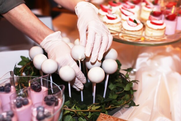 Mesa de catering com bolos de chocolate fatiados, decorados com framboesas frescas e nozes.