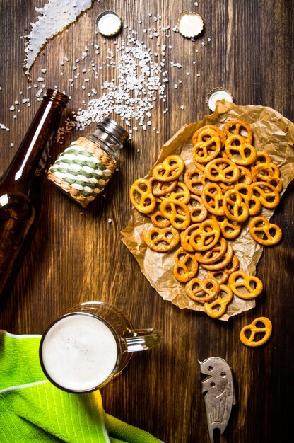 Foto mesa de cerveja - uma garrafa caída, cerveja, biscoitos salgados