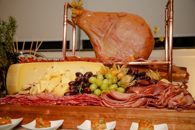 Mesa de comida lindamente decorada para eventos com carreto de queijo e cordeiro.