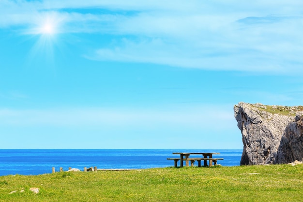 Mesa de descanso com bancos na costa do mar ensolarado de verão perto de Camango Asturias Espanha