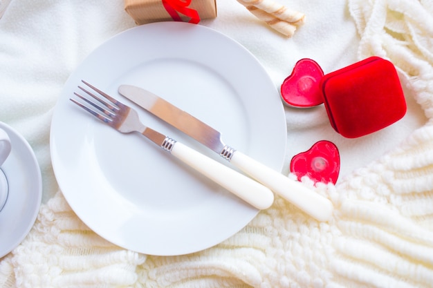 Mesa de dia dos namorados com caixa de veludo vermelho, velas e talheres