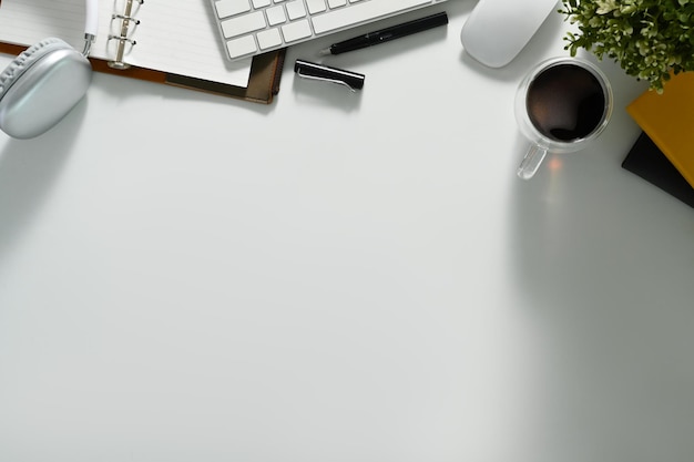Mesa de escritório branca de vista superior com xícara de café para notebook de fone de ouvido e teclado Copie o espaço para o seu texto