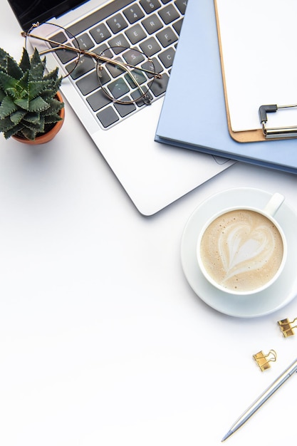 Mesa de escritório branca moderna com notebook portátil e outros suprimentos