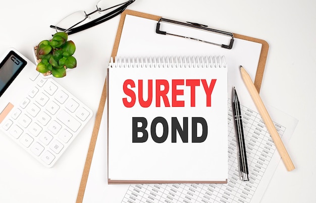 Mesa de escritório com bloco de notas de folha de papel e calculadora Vista superior SURETY BOND