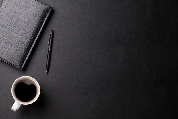 Mesa de escritório com bloco de notas e caneta de café