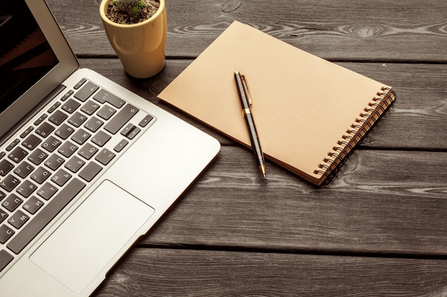 Mesa de escritório com copo e café em branco laptop