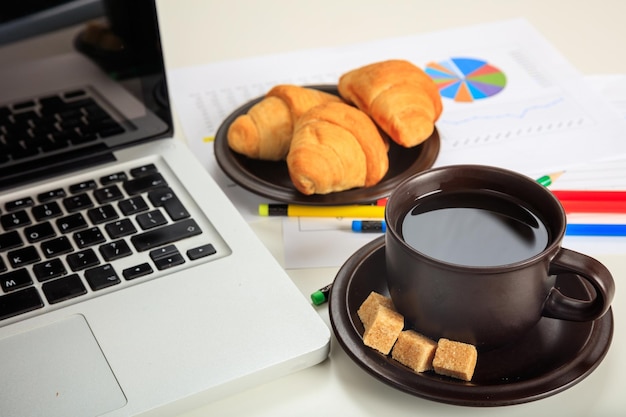 Mesa de escritório com laptop e uma xícara de café