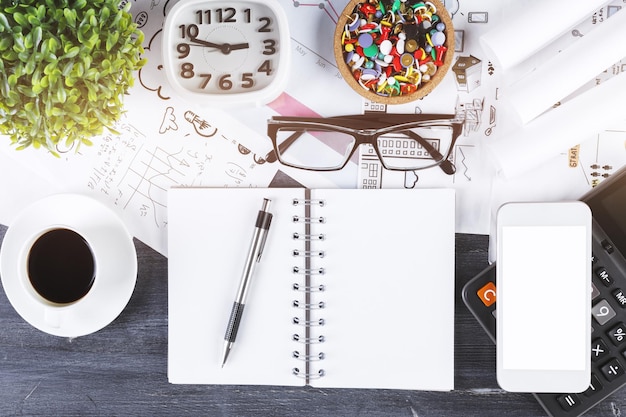 Mesa de escritório com smartphone e bloco de notas