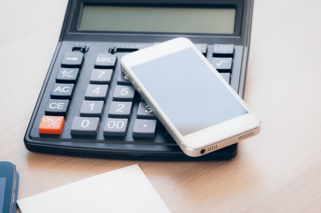 Mesa de escritório com smartphone e suprimentos close-up