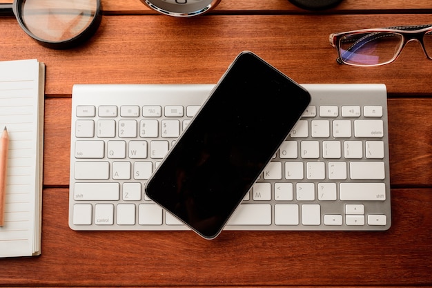 Mesa de escritório com smartphone e suprimentos. Vista do topo.