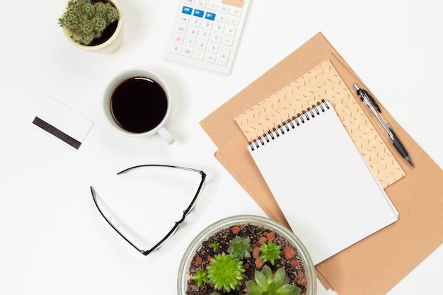 Mesa de escritório com suprimentos e cactus