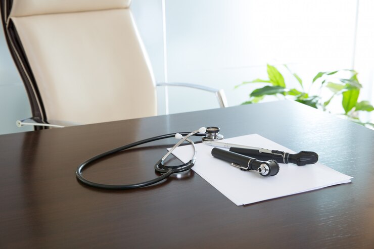 Foto mesa de escritório de médico com estetoscópio e otoscópio
