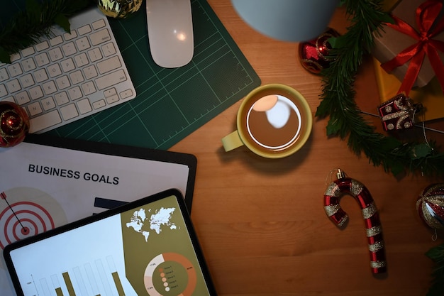 Mesa de escritório de natal de madeira com decoração de tablet digital e suprimentos de trabalho conceito de férias de negócios