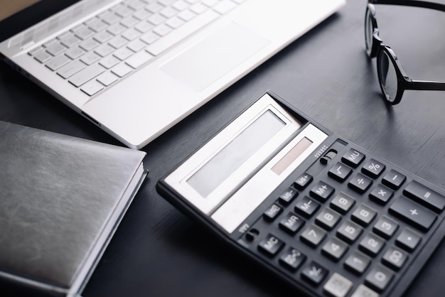 Mesa de escritório do espaço de trabalho do contador com calculadora portátil e óculos retratando práticas modernas de finanças e contabilidade