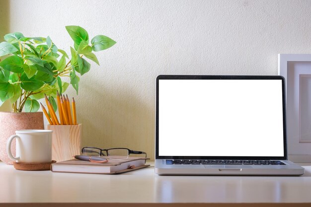 Mesa de escritório em casa com planta em vaso de xícara de café para laptop e papel de carta Tela em branco para o seu texto de anúncio