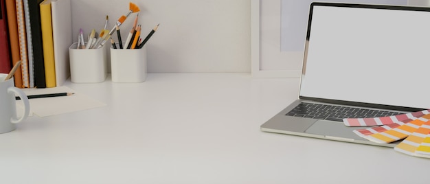 Foto mesa de escritório em casa de design com laptop, ferramentas de pintura, suprimentos e cópia espaço