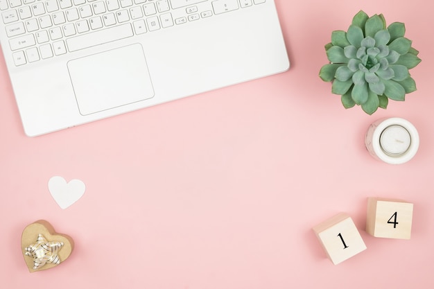 Mesa de escritório em casa plana leigos. Espaço de trabalho de mulheres com laptop e decoração na superfície rosa. Conceito dia dos namorados