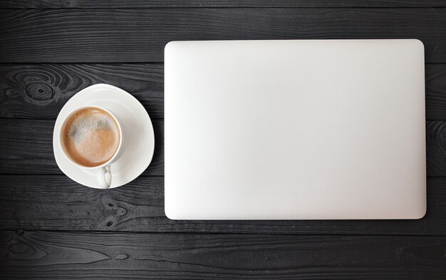 Mesa de escritório - laptop e copo de café na textura de madeira e fundo com espaço de cópia.