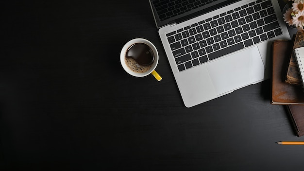 Mesa de escritório plana vista superior leigos. Espaço de trabalho com computador portátil e material de escritório na tabela preta.