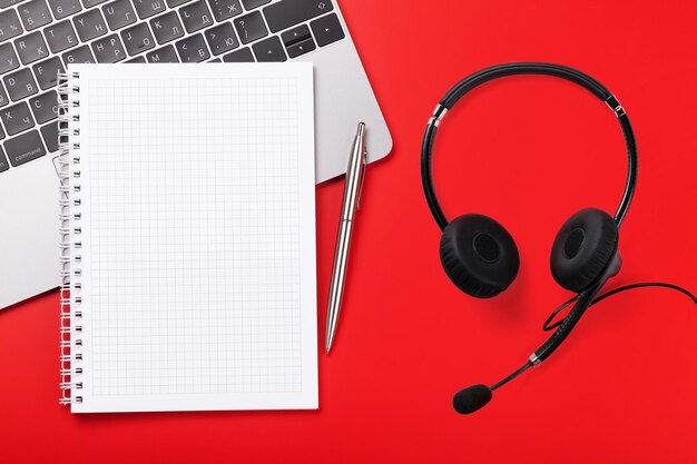 Mesa de escritório vermelha com suprimentos e fone de ouvido