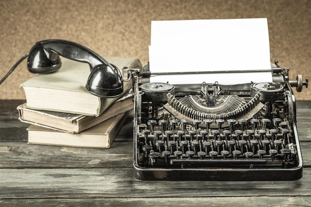 Mesa de escritório vintage com máquina de escrever, telefone e livros