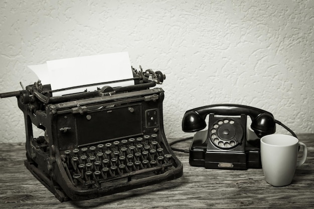 Mesa de escritório vintage com máquina de escrever, telefone na mesa
