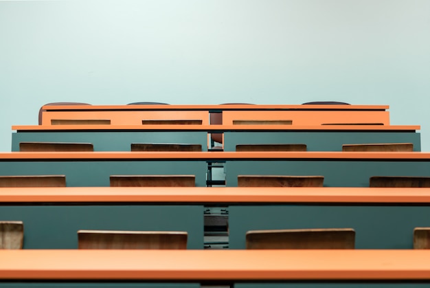 Foto mesa de estudante vazia com cadeira de madeira na sala de aula de palestra da faculdade