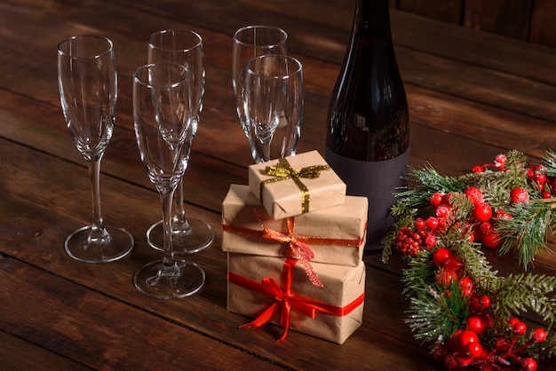 Mesa de férias de Natal com copos e uma garrafa e presentes