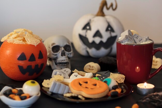 Foto mesa de festa de halloween com guloseimas, bebidas quentes e lanches