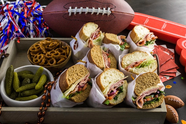 Foto mesa de futebol para festa de dia de jogo com sanduíche e lanches.