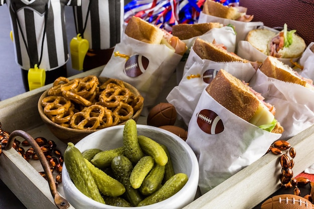 Mesa de futebol para festa de dia de jogo com sanduíche e lanches.