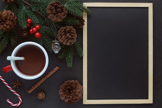 Mesa de granito preto decorar com lousa ou lousa, folha de pinheiro e cones e xícara de chocolate no conceito de Natal