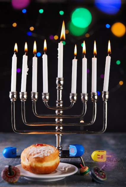 Mesa de Hanukkah, definindo um castiçal com velas, rosquinhas e piões em azul