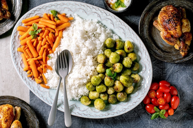 Mesa de jantar com frango grelhado, arroz e legumes