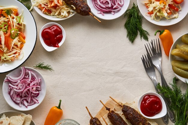 Mesa de jantar com kebab de carne, salada fresca e ervas