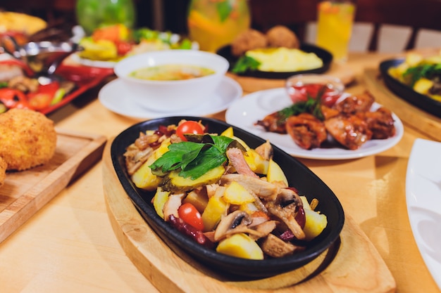 Mesa de jantar com uma variedade de lanches e saladas. salmão, azeitonas, vinho, legumes, torradas de peixe grelhado. o conceito de um jantar de comemoração em família.