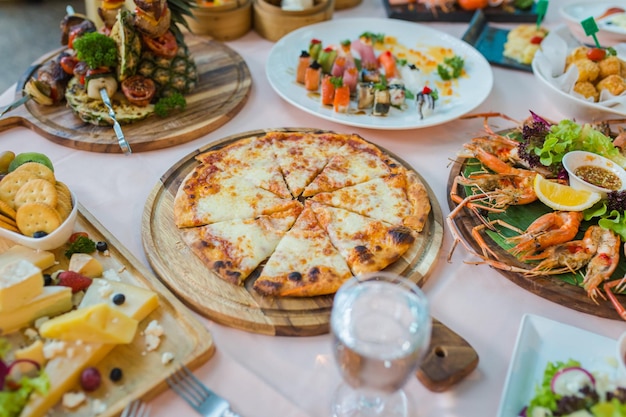 Mesa de jantar com variedade de comida pizza frutos do mar e sushi