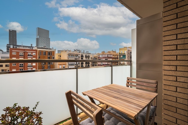 Foto mesa de jantar de madeira com cadeiras na varanda com grade de vidro fosco um lugar aconchegante para relaxar