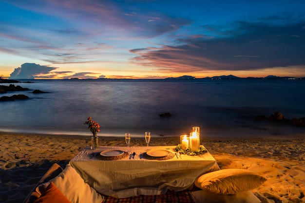 Mesa de Jantar Romântica ao lado da praia no crepúsculo do pôr do sol na Ilha Munnok Tailândia