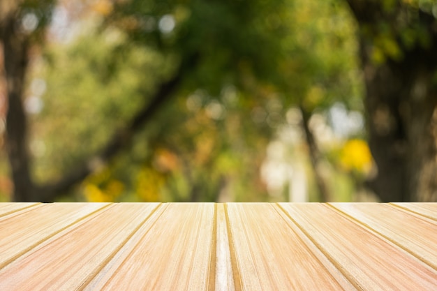 Foto mesa de madeira amarela vazia com parque da cidade turva