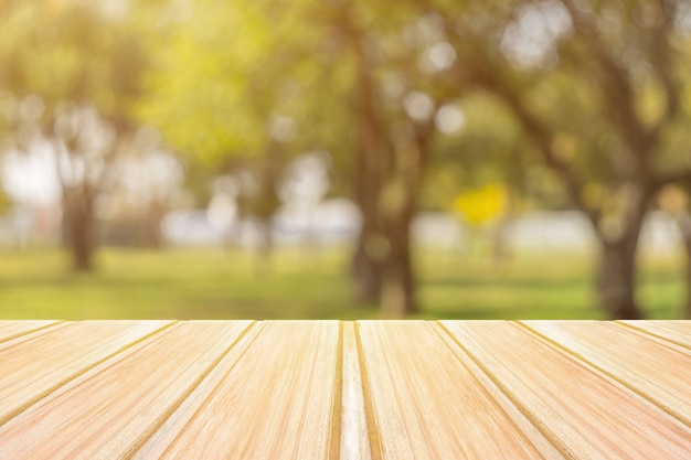 Foto mesa de madeira amarela vazia com parque da cidade turva