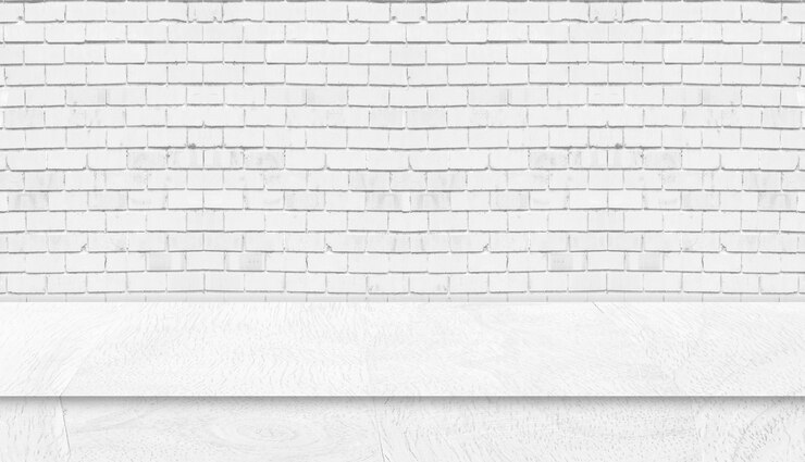 Foto mesa de madeira branca com fundo da parede de tijolo branco