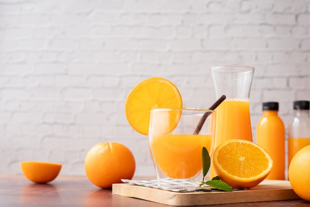 Mesa de madeira com copos de suco de laranja espremido na hora, sem adição de açúcar.