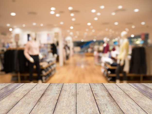 Mesa de madeira com fundo de loja de roupas desfocadas em shopping