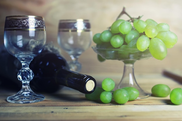 Mesa de madeira com livro de garrafa de vinho e uva