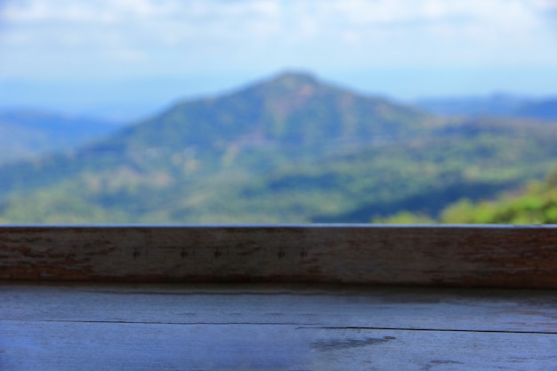 Mesa de madeira com paisagem turva da montanha verde