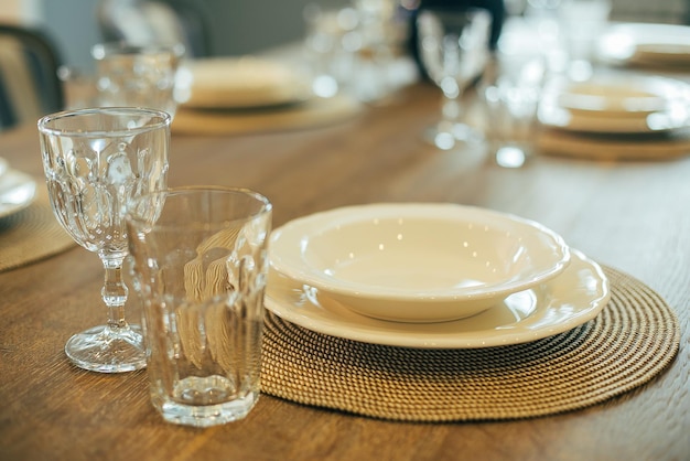 Foto mesa de madeira com pratos vazios e copos configuração de mesa de jantar