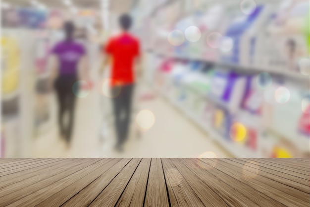 Foto mesa de madeira mesa vazia em frente ao fundo desfocado. perspective light wood over blur in supermarket - pode ser usado para exibir ou montar seus produtos. mock up para exibição de produto.