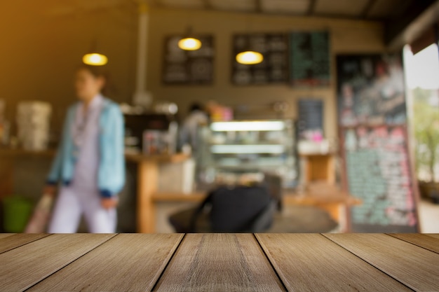 Mesa de madeira para o presente produto com coffee shop blur background feito com tons vintage.